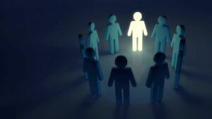 white figure illustration surrounded by group shrouded in darkness